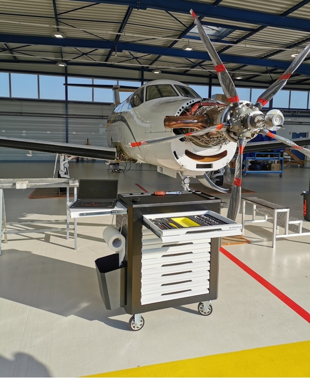 Aircraft maintenance workshop tool trolley beside a Pilatus-RC12